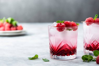 Nane yaprağı ve buz küpleriyle ahududu soğuk kokteyli. Bardakta taze yaz içeceği