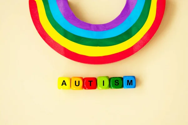 Autism word wooden colorful cubes and rainbow. Mental health. Special education concept