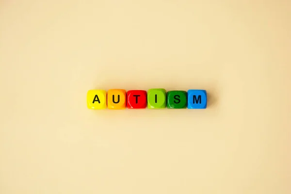 Autism word wooden colorful cubes and rainbow. Mental health. Special education concept