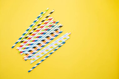 Biyolojik çözünebilir kağıt eko pipetleri. Sarı arka planda hiç çöp kamışı yok. Metin için alanı kopyala.