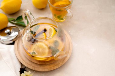 Parlak arkaplanda meyveli narenciye çayı olan cam çaydanlık. Bitkisel lezzetli sağlıklı çay, metin için kopyalama alanı