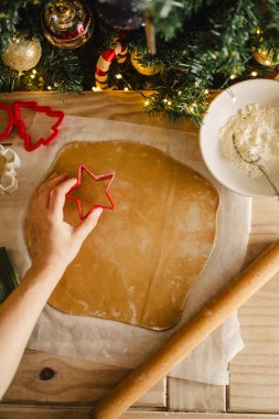 Tatil geçmişi. Yuvarlanan broşlu kadın, eller ve rulo hamurlar, Noel kurabiyesi pişirme. Üst görünüm