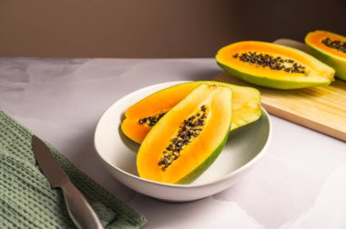 Tabakta Papaya egzotik meyve parçaları var. Sağlıklı vejetaryen yemekleri.