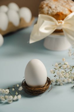 Yuvada Paskalya beyaz yumurtası ve beyaz çiçekli Paskalya pastası. Bahar tatili geçmişi.
