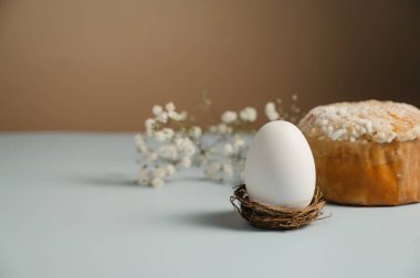 Yuvada Paskalya beyaz yumurtası ve beyaz çiçekli Paskalya pastası. Bahar tatili geçmişi.