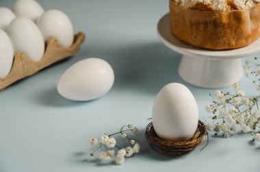 Yuvada Paskalya beyaz yumurtası ve beyaz çiçekli Paskalya pastası. Bahar tatili geçmişi.