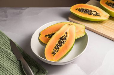 Tabakta Papaya egzotik meyve parçaları var. Sağlıklı vejetaryen yemekleri.