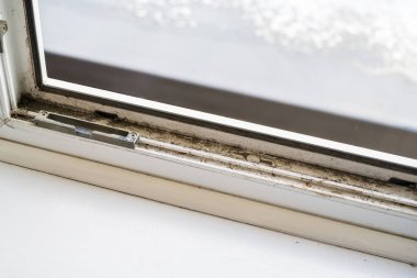 Kirli plastik pencere. Toz kaplı plastik pencere çerçevesi ve pervazı toprak birikintisi ve lekelerle kaplı.