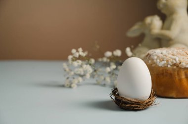 Yuvada Paskalya beyaz yumurtası ve beyaz çiçekli Paskalya pastası. Bahar tatili geçmişi.