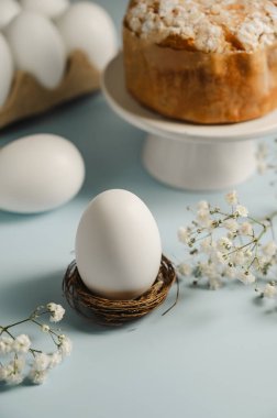 Yuvada Paskalya beyaz yumurtası ve beyaz çiçekli Paskalya pastası. Bahar tatili geçmişi.