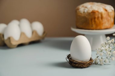 Yuvada Paskalya beyaz yumurtası ve beyaz çiçekli Paskalya pastası. Bahar tatili geçmişi.