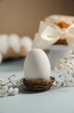 Yuvada Paskalya beyaz yumurtası ve beyaz çiçekli Paskalya pastası. Bahar tatili geçmişi.
