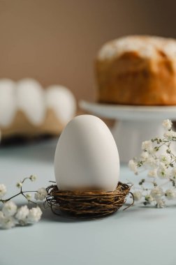 Yuvada Paskalya beyaz yumurtası ve beyaz çiçekli Paskalya pastası. Bahar tatili geçmişi.