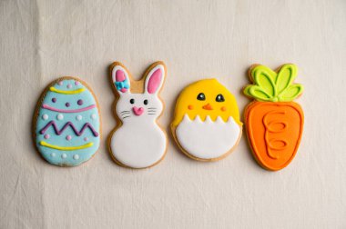 Renkli paskalya kurabiyeleri: Tavşan, havuç, yumurta, parlak, tekstil arka planda izole edilmiş civciv. Üst görünüm, alanı kopyala