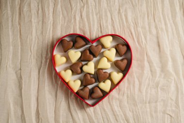 Sevgililer Günü çikolataları, kırmızı kalp şeklinde kutularda, tarafsız arka planda. Üst görünüm, alanı kopyala