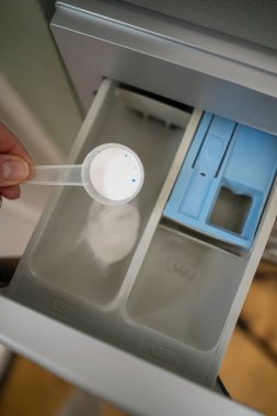 Akıllı ev aletleri. Çamaşır makinesine deterjan tozu döküyorum. Üst görünüm