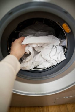 Günlük ev işleri. Akıllı aletler. Evde çamaşır makinesinden yüklenen ya da indirilen beyaz elbiseler