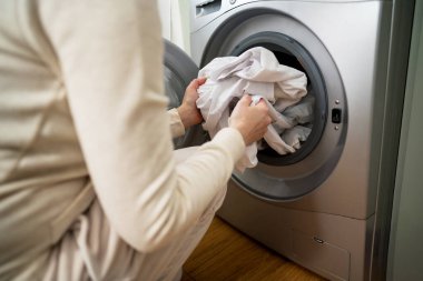 Günlük ev işleri. Akıllı aletler. Evde çamaşır makinesinden yüklenen ya da indirilen beyaz elbiseler