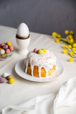 Paskalya bayramı pastası, kremalı, şekerli ve yumurtalı. Beyaz yumurta ve bahar, sarı çiçek dalları.