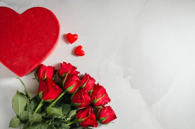 Sevgililer Günü geçmişi. Kırmızı güller çiçekler ve parlak arka planda kalp hediye kutusu. Kutlama kartı, düz yatış.