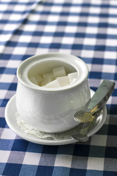 Sugar-bowl with a lump sugar on a table — Stock Photo, Image