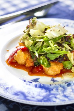 Kızarmış balık fileto, kırmızı biber ve salata karışımı salata