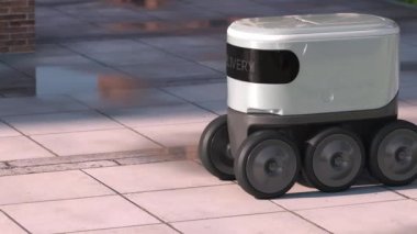 Yağmurdan sonra sabah sokağında otomatik dağıtım robotu sürüyor.