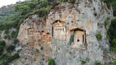 Türkiye 'nin Dalyan kentinin karşısındaki kayalıklarda bulunan Lycian kaya mezarları. Kralların mezarları. İnsansız hava aracıyla yavaş uçuş. 4K