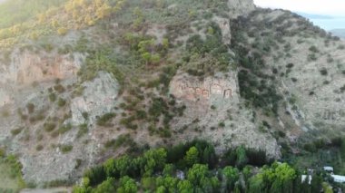 Türkiye 'nin Dalyan kentinin karşısındaki kayalıklarda bulunan Lycian kaya mezarları. Kralların mezarları. İnsansız hava aracıyla mezarlara yaklaşıyoruz. 4K