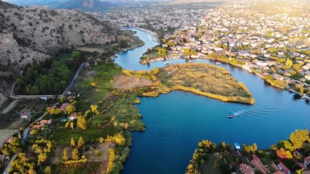 Widok z powietrza kręta niebieska rzeka i małe miasteczko o zachodzie słońca. Strzał drona. Dalyan, Turcja. 4K — Wideo stockowe