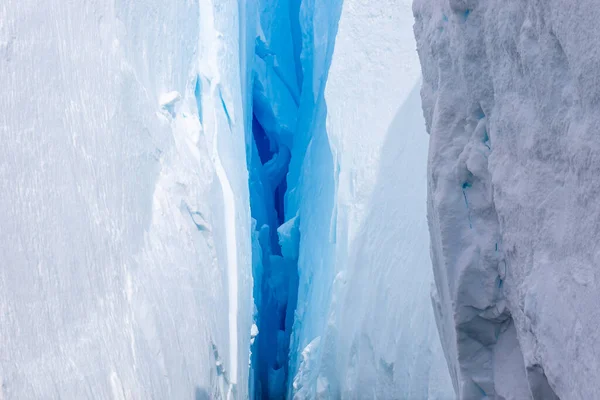 Antarktika 'da bir buzulda derin mavi bir çatlak. Yakın plan. Buzulda bir çatlak. Küresel sıcaklık.