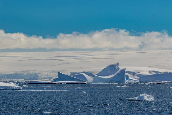 Antarktika 'nın arka planında büyük bir buzdağı olan güzel bir buzdağı..