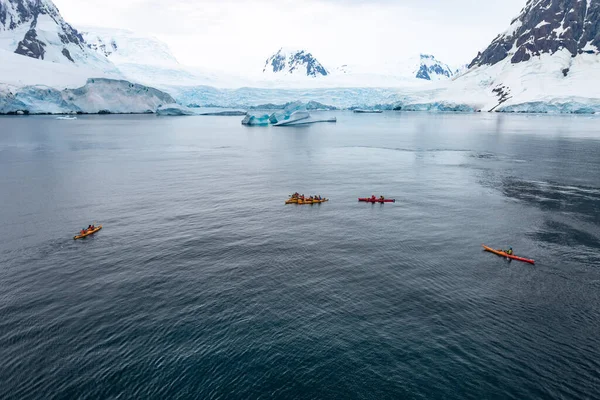 Antarktika 'da kış kanosu. Ekstrem spor macerası. Lemaire Kanalı 'nda insanlar kanoyla kürek çekiyor.