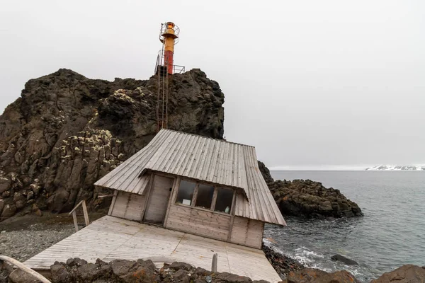 Antarktika 'da deniz kenarında köhne bir ev.