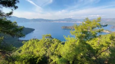Bir adası olan kapalı bir körfezin inanılmaz manzarası. Büyüleyici gökyüzü olan güzel bir manzara. Kameranın yukarı hareketi.