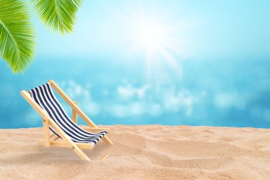 Yaz tatili kavramı: Sahildeki kumsal sandalyesi deniz manzarası ve arka planda mavi gökyüzü..