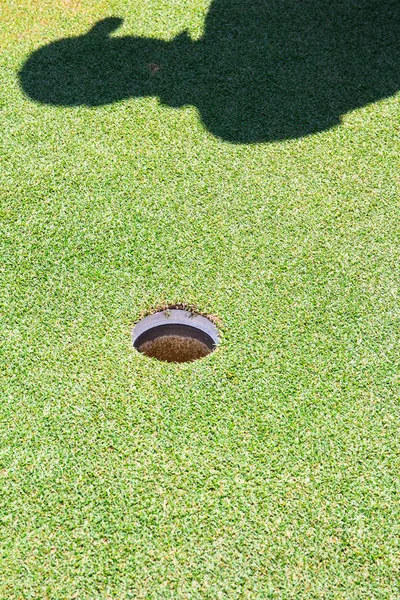 Buraco de golfe e sombra do jogador — Fotografia de Stock