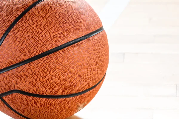 Basketbalový míč nad podlahou v tělocvičně — Stock fotografie