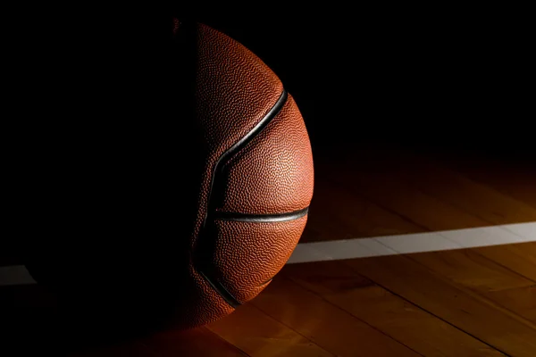 Basketbal izolovaných na soud černé pozadí s Světelný efekt — Stock fotografie