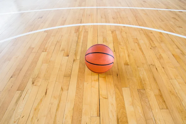 Basketbalový míč nad podlahou v tělocvičně — Stock fotografie