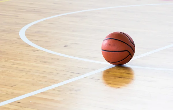 Baloncesto pelota sobre el piso en el gimnasio — Foto de Stock