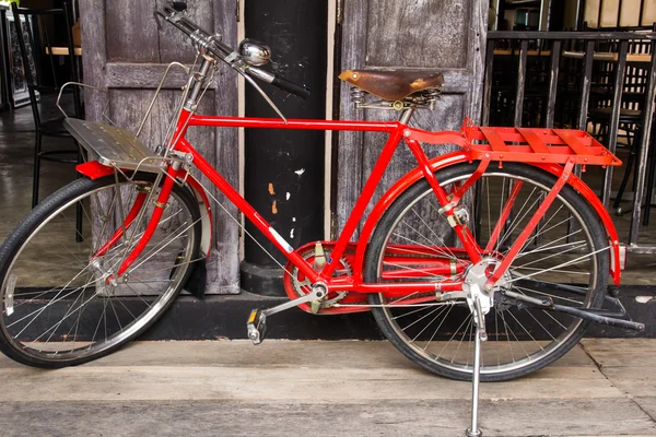 Bicicleta roja vintage en madera vintage — Foto de Stock