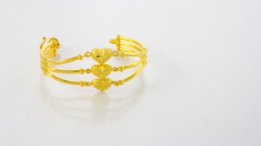 Beyaz zemin üzerinde altın bilezik