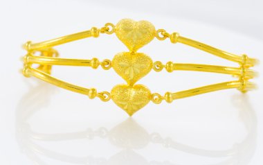 Beyaz zemin üzerinde altın bilezik