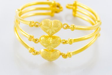 Beyaz zemin üzerinde altın bilezik