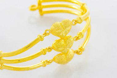 Beyaz zemin üzerinde altın bilezik