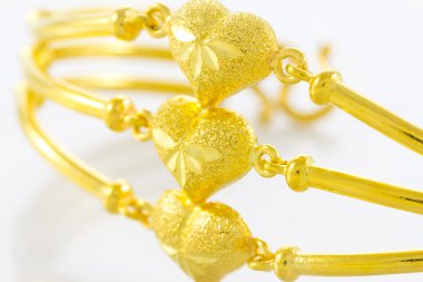 Beyaz zemin üzerinde altın bilezik