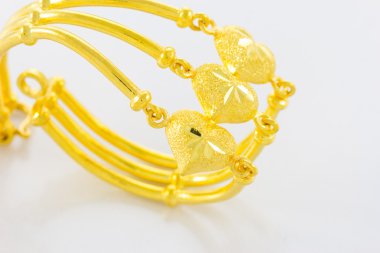 Beyaz zemin üzerinde altın bilezik