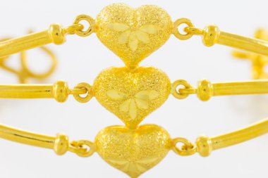 Beyaz zemin üzerinde altın bilezik