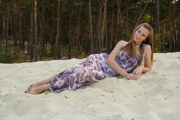 Vacker kvinna på sand nära skogen av tall — Stockfoto